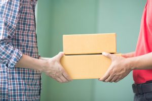 Two men exchanging cardboard boxes