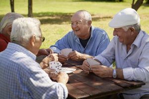group of elderly men playing cards in a park