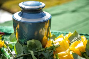 Blue metallic urn surrounded by yellow flowers