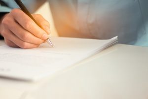 Person writing on a document