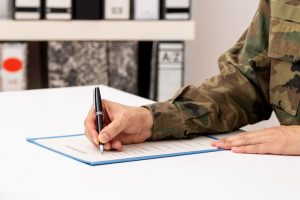 Administrative military service member providing DD 214 documentation, signing it
