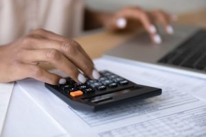 Woman using a calculator to calculate the cost