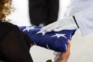 Next of kin receiving the burial flag from a uniformed service member