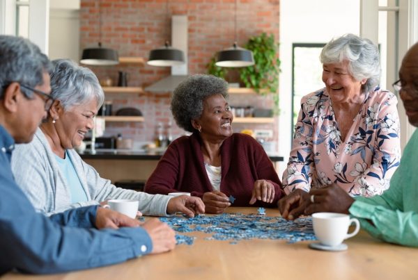 group of elderly friends working on a puzzle together