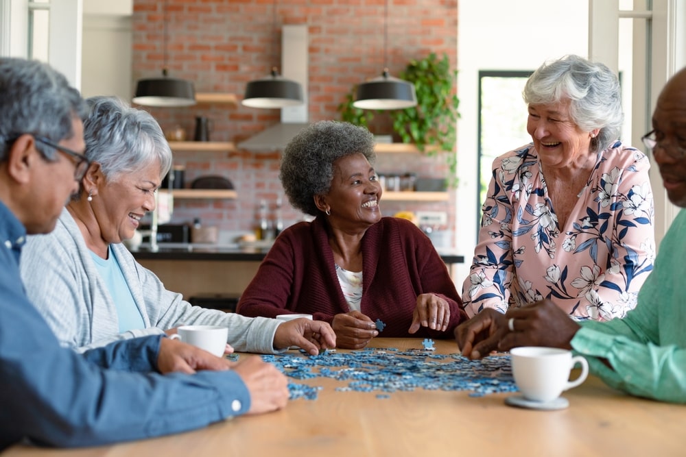 group of elderly friends working on a puzzle together