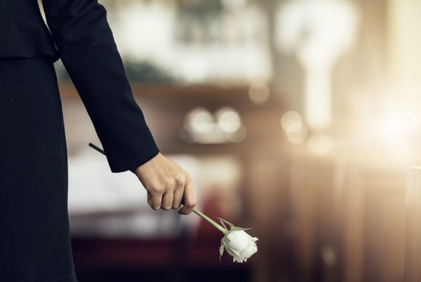 Woman wearing black and holding a white rose