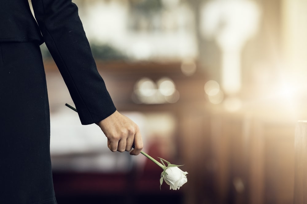 Woman wearing black and holding a white rose