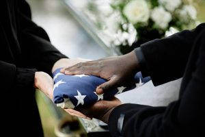 Next of kin receiving a folded flag during a veteran funeral