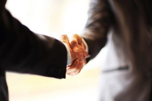 Two men in suits shaking hands