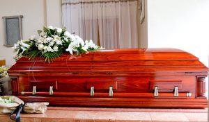 Dark wood casket with funeral spray resting on top