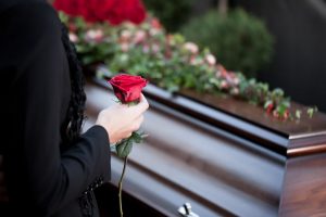 woman placing a rose at a loved one's funeral