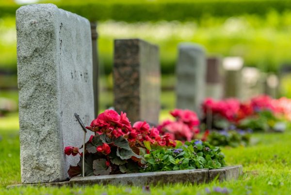 Row of gravestones with flowers at a cemetery