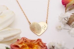Keepsake necklace with a loved one's fingerprint and the word "Dad" engraved on it