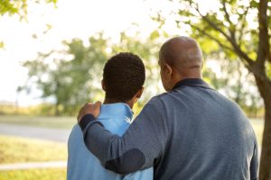 Father comforting his son outside in the fall