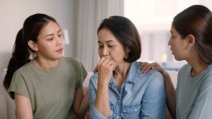 two daughters comforting their mother