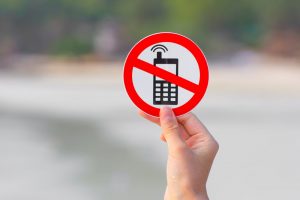 person holding up a no phones sign