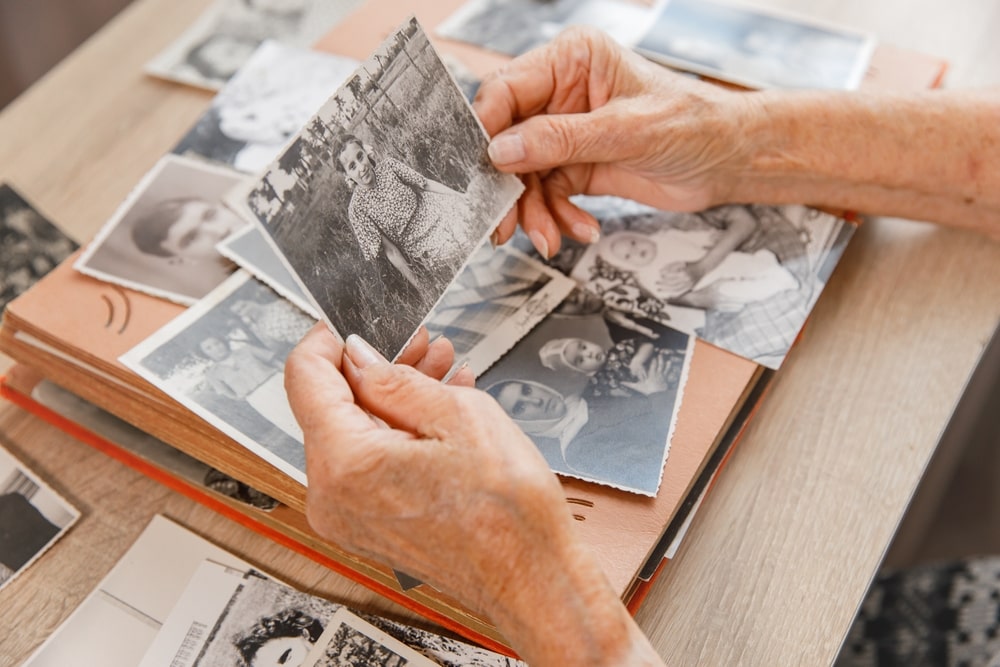 older person looking at black and white photos 