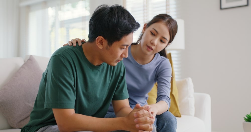 young woman comforting a young man