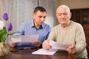 Man and his elderly father looking at medical documents together