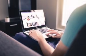 Woman sitting in chair at home, checking social media accounts