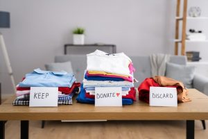 Clothes sorted into keep, donate, and discard stacks