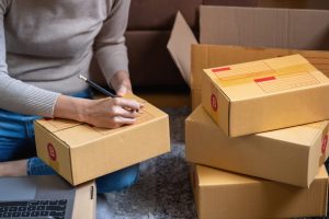 Woman addressing care package boxes