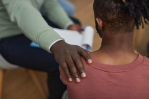 Man putting comforting hand on the shoulder of a friend