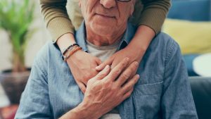 Woman resting arms on her father's shoulders