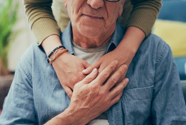 Woman resting arms on her father's shoulders