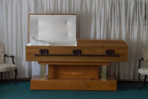 light tan half couch casket with one lid open