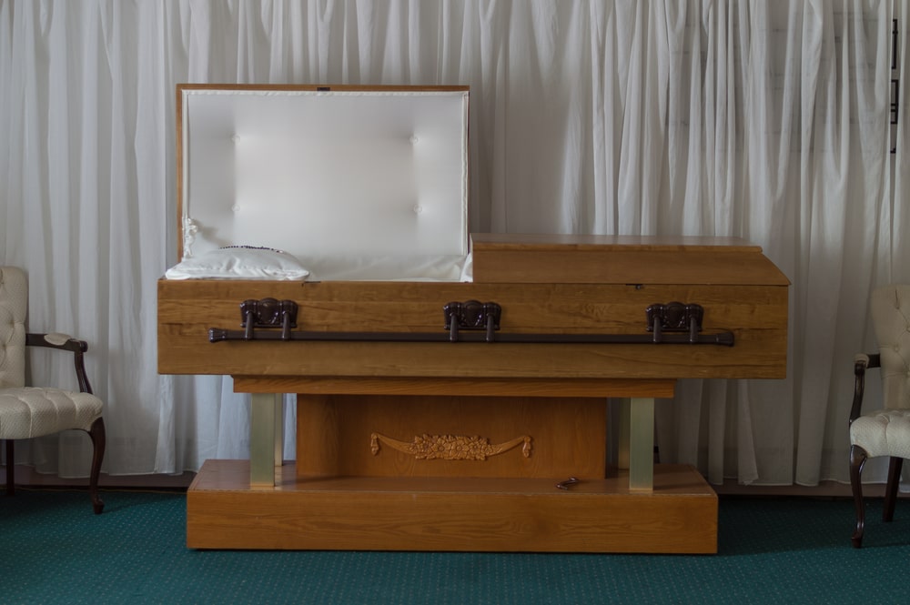light tan half couch casket with one lid open
