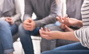 Suicide loss support group with woman sharing her story