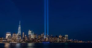 NYC night skyline with two lights lighting the sky in place of the Twin Towers