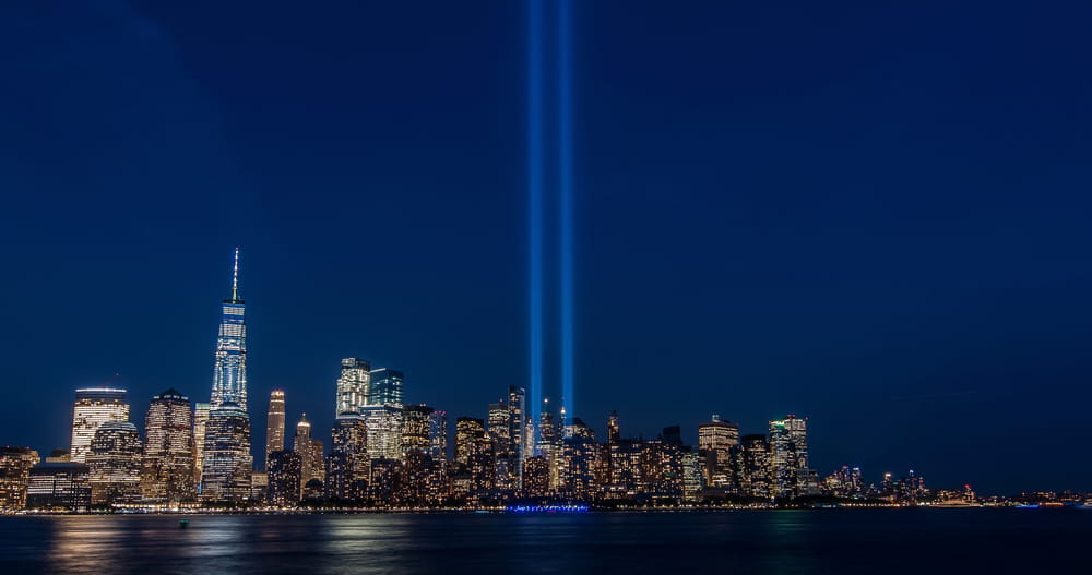 NYC night skyline with two lights lighting the sky in place of the Twin Towers