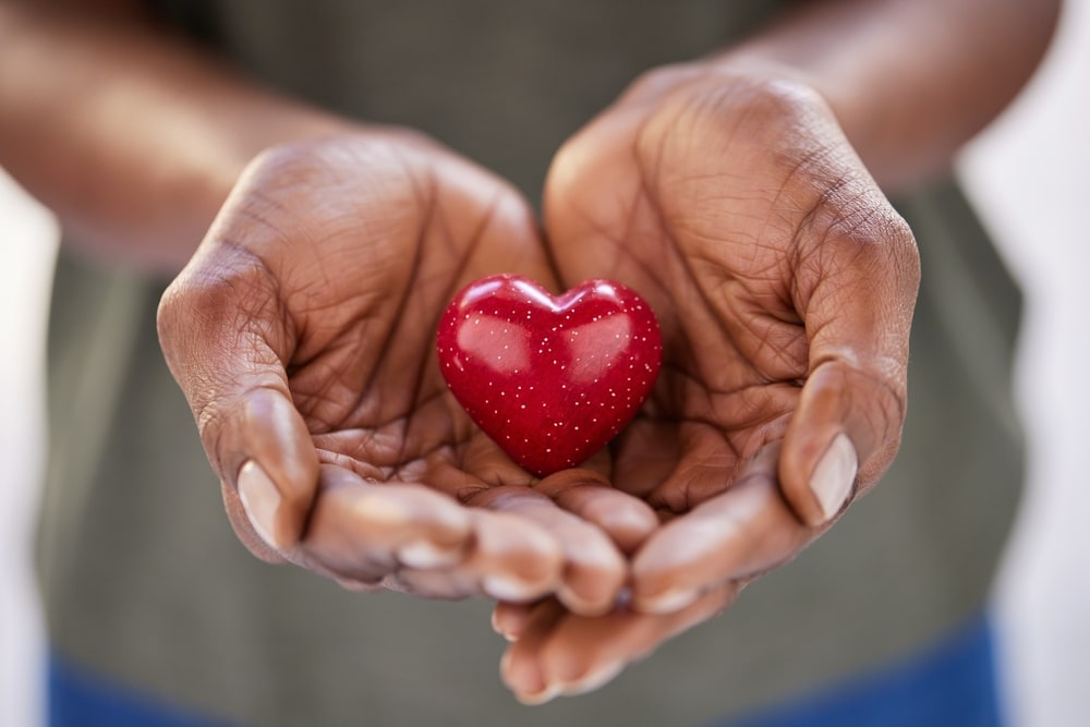 Person holding a small heart in their hands