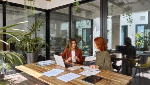 Two businesswomen in a one-on-one meeting, talking about grief and work tasks