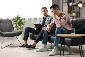 Two male colleagues sitting on a couch as one talks about his grief