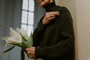 Woman holding white lilies at a funeral