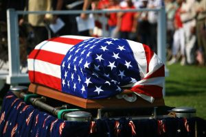 Casket with flag wrapped around it as part of military honors