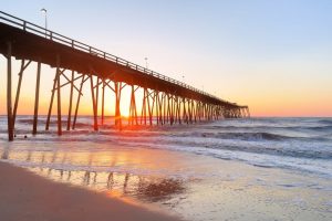 Wooden pier stretching out into water at a beach