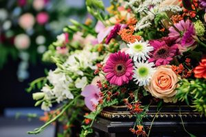 Bright bouquet of flowers resting on top of casket