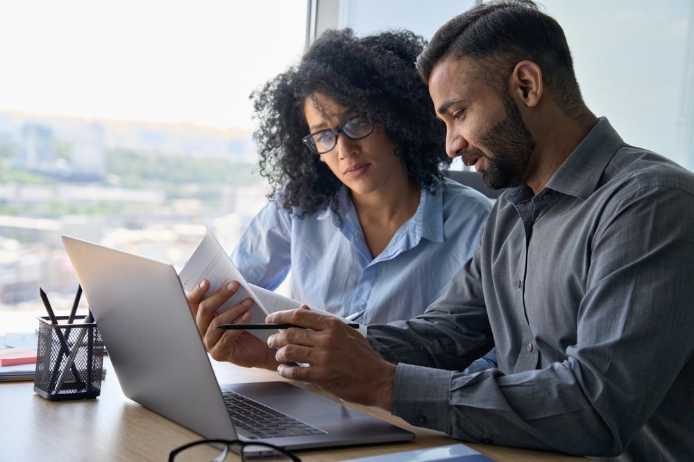 Man and woman looking at computer and reviewing policies