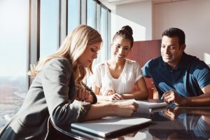 Insurance agent reviewing insurance policy with young couple