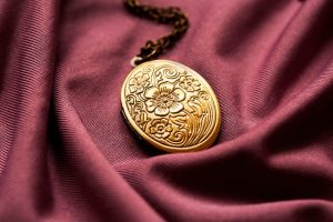 A golden locket with an engraved flower design