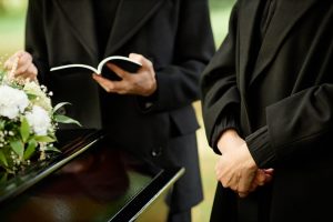Officiant reading from book at graveside service