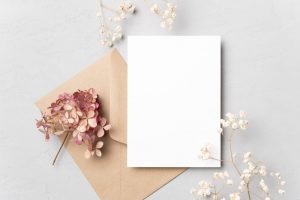 White paper with beige envelope with pink and white flowers