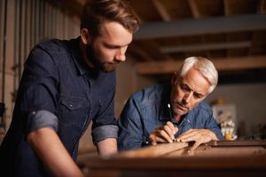 Father and adult son working on carpentry together