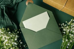 Ivory card resting in a olive green envelope