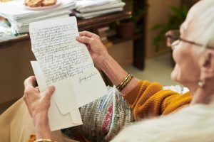 Senior woman reading a handwritten letter with words of affirmation and encouragement