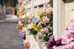 A columbarium with cremation niches and many bouquets of many colors